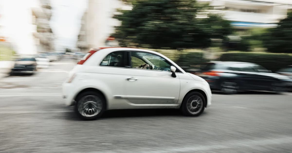 voiture blanche qui roule en ville. crédit : Matheus Bertelli